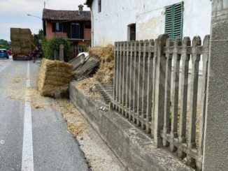 Un camion urta la staccionata di una casa e perde pesanti balle di paglia